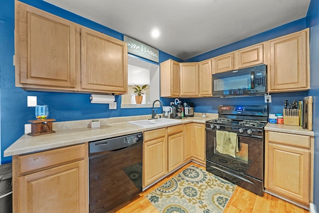 kitchen with sink, light brown cabinets, black appliances, and light wood-type flooring