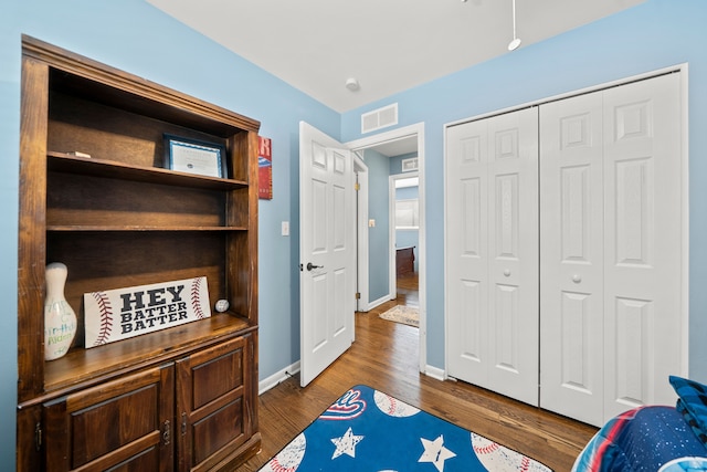 bedroom featuring dark wood-type flooring and a closet