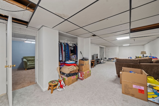 basement featuring light carpet and a drop ceiling