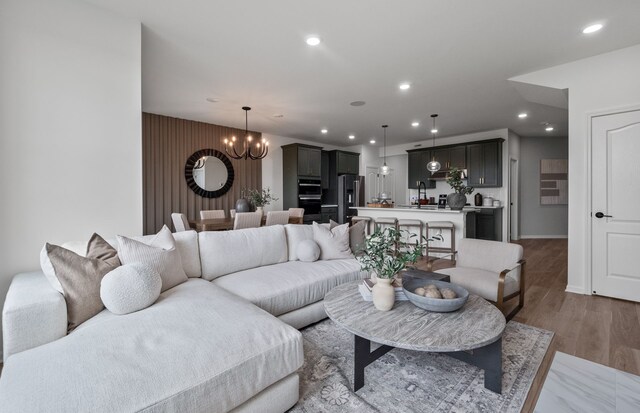 living room with an inviting chandelier and light hardwood / wood-style floors