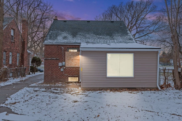 view of snow covered rear of property