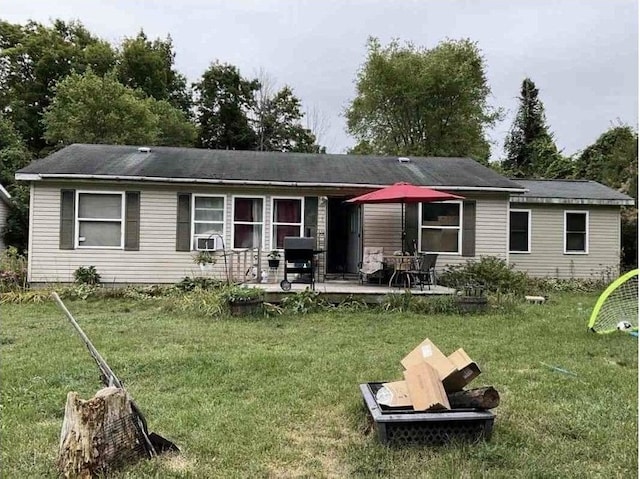 back of property featuring a patio area, an outdoor fire pit, and a yard