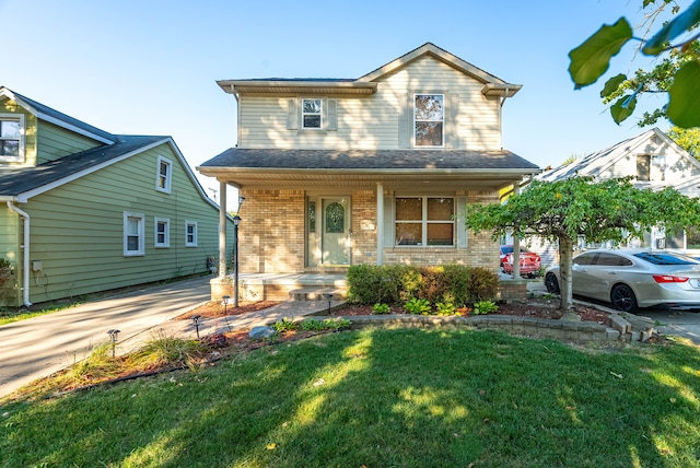 view of property featuring a porch and a front lawn