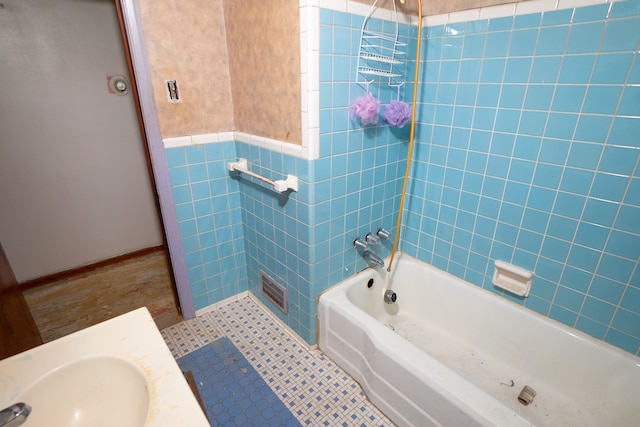 bathroom with tile patterned flooring, tiled shower / bath, and sink