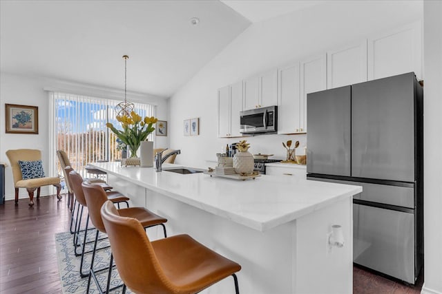 kitchen featuring pendant lighting, sink, a kitchen island with sink, stainless steel appliances, and white cabinets