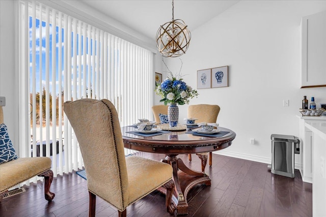 dining room featuring dark wood-type flooring, a wealth of natural light, and a chandelier