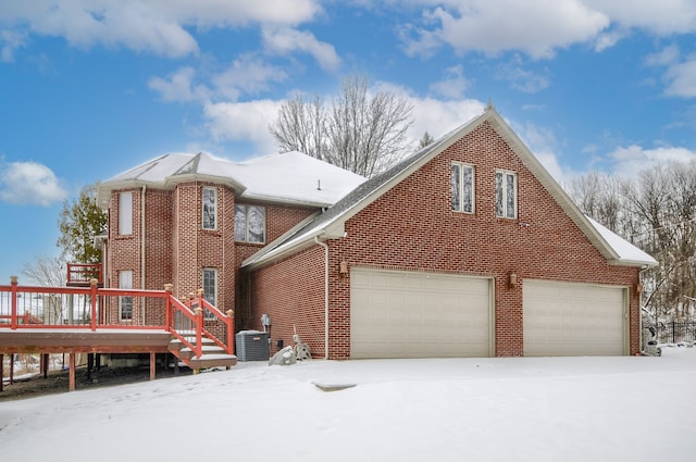 exterior space with central air condition unit, a deck, and a garage