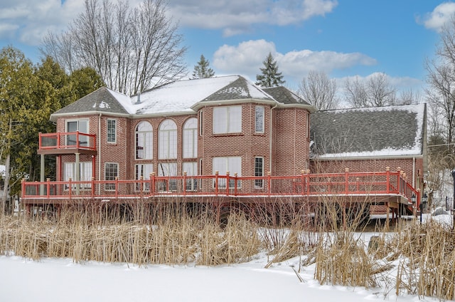 snow covered house with a deck and a balcony