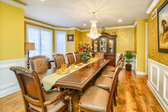 dining space featuring an inviting chandelier, light wood-type flooring, and crown molding