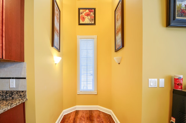 hallway with hardwood / wood-style flooring