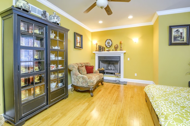 bedroom with ornamental molding, ceiling fan, and wood-type flooring