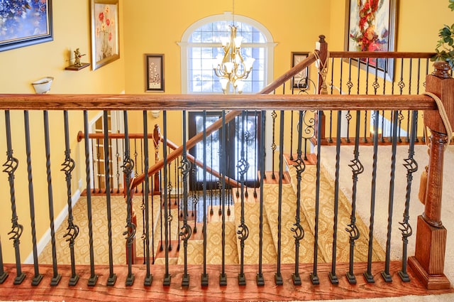 stairs featuring a notable chandelier