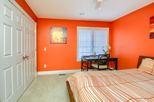 carpeted bedroom with ceiling fan and a closet