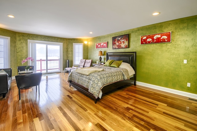 bedroom with access to exterior and hardwood / wood-style floors