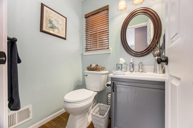 bathroom featuring toilet, vanity, and hardwood / wood-style flooring