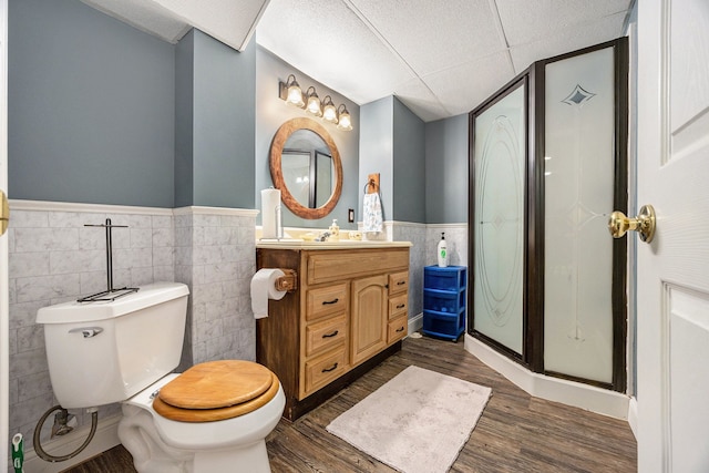 bathroom with tile walls, toilet, vanity, and hardwood / wood-style flooring