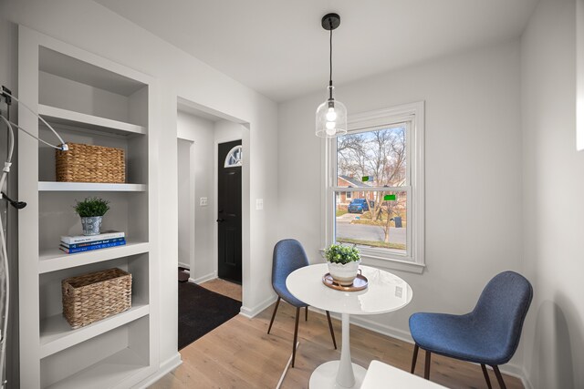 sitting room with built in features and hardwood / wood-style flooring