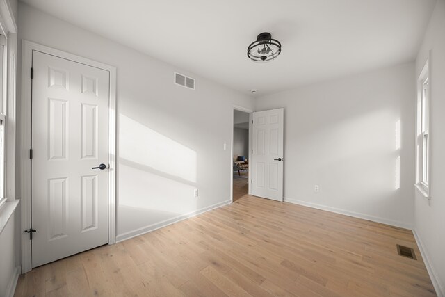 unfurnished bedroom with multiple windows and light hardwood / wood-style flooring