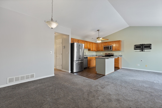 kitchen featuring dark carpet, ceiling fan, appliances with stainless steel finishes, lofted ceiling, and a kitchen island