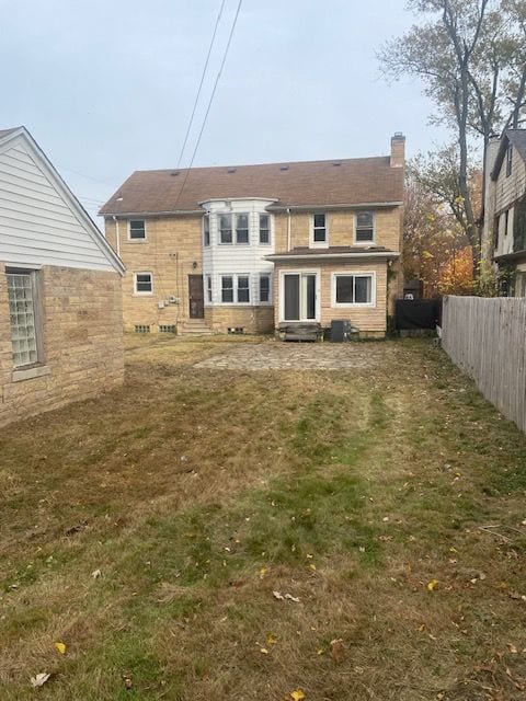 rear view of property with a lawn