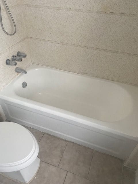 bathroom with toilet, tile patterned flooring, and shower / bath combination