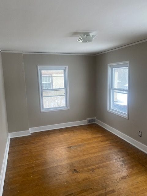 spare room with hardwood / wood-style floors and ornamental molding