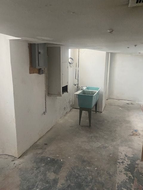 basement featuring electric panel and sink