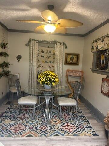 dining room featuring a textured ceiling, ornamental molding, and ceiling fan