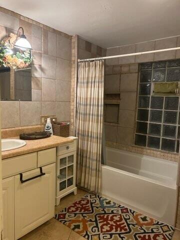 bathroom featuring vanity, tile patterned flooring, tile walls, and shower / bath combination with curtain