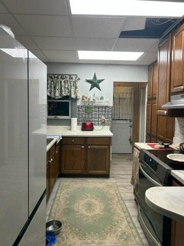 kitchen with a paneled ceiling and stainless steel refrigerator