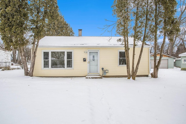 view of front of property with a garage and an outdoor structure