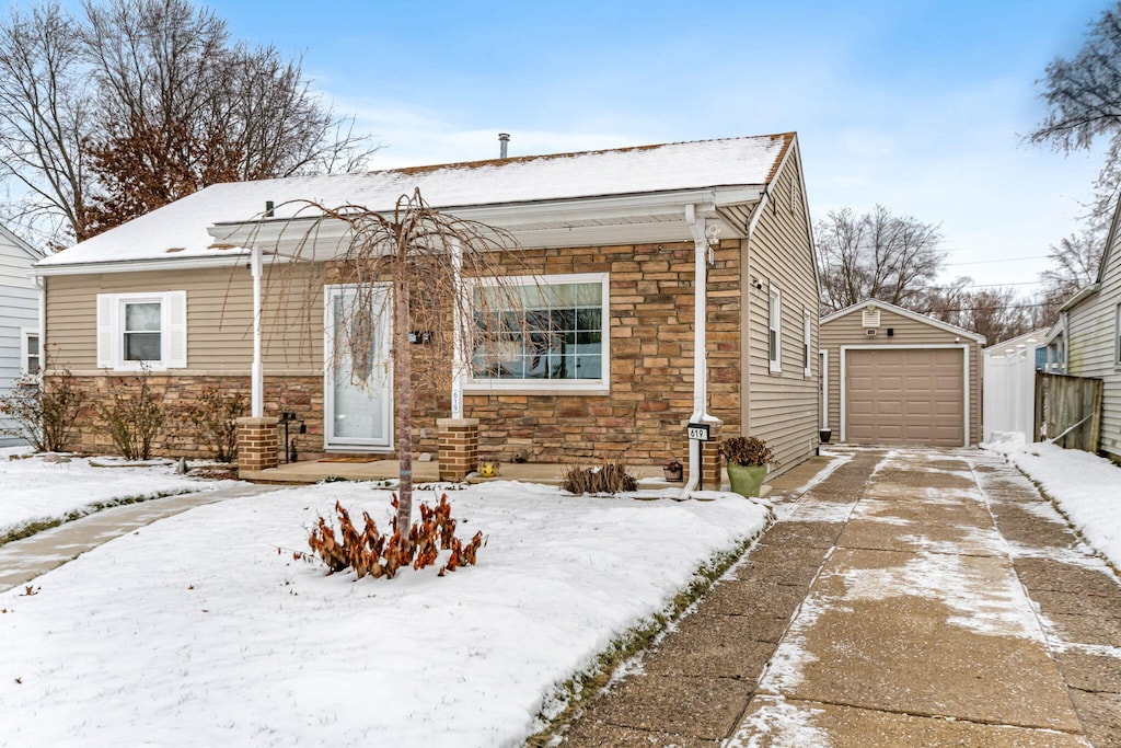 bungalow-style home with a garage and an outbuilding