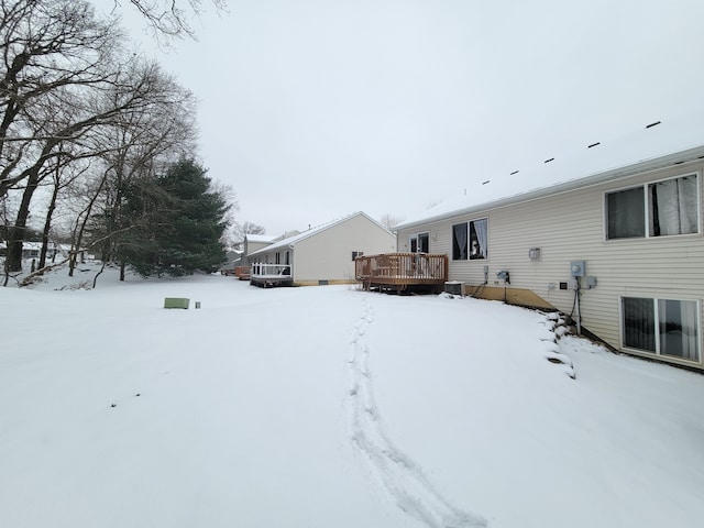 yard layered in snow with a deck