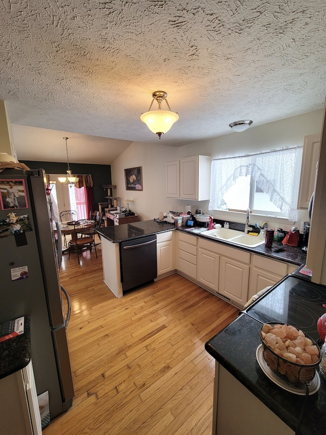 kitchen with dishwashing machine, freestanding refrigerator, a peninsula, white cabinetry, and a sink