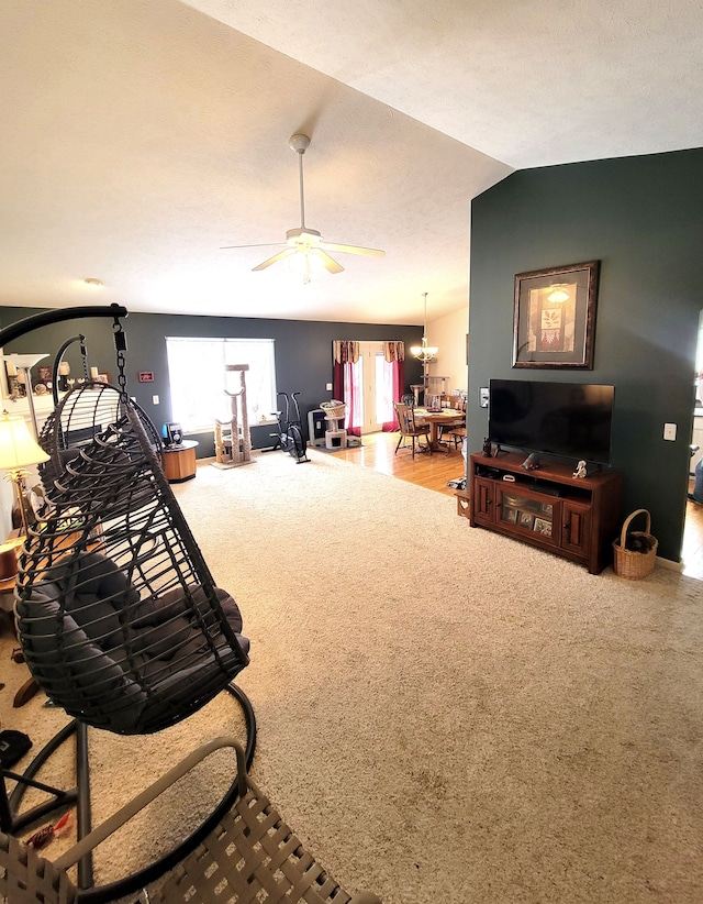 carpeted living room featuring a ceiling fan, vaulted ceiling, and a wealth of natural light