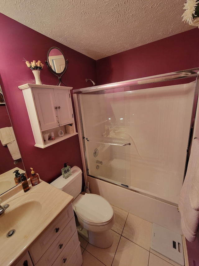 full bathroom featuring toilet, shower / bath combination with glass door, a textured ceiling, tile patterned floors, and vanity