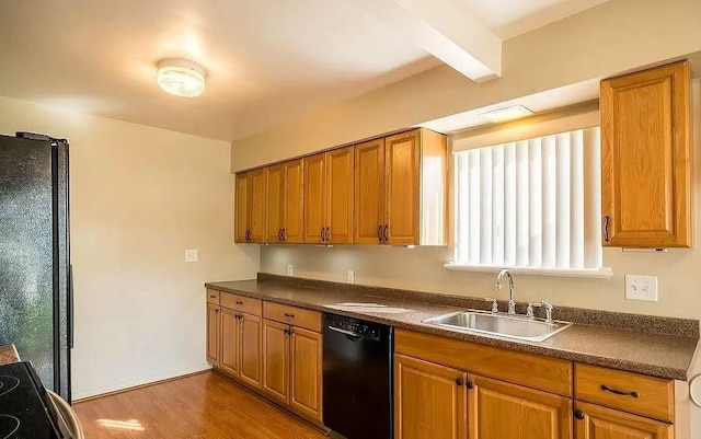 kitchen with beam ceiling, light hardwood / wood-style floors, black appliances, and sink