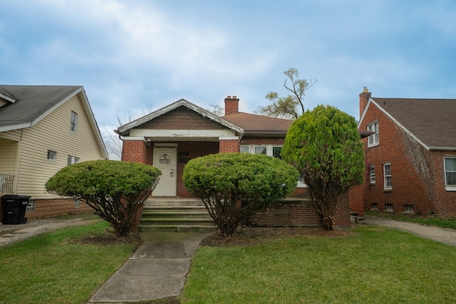 bungalow-style home featuring a front lawn