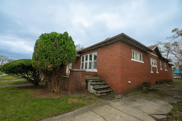 view of side of home with a lawn