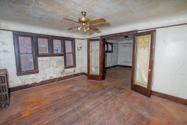 interior space with ceiling fan, dark hardwood / wood-style flooring, and radiator heating unit