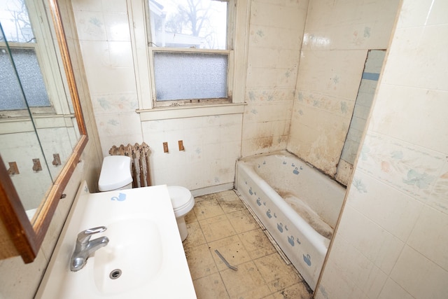 bathroom with toilet, a tub, and sink