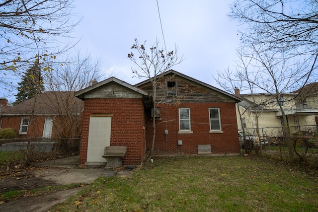 rear view of property featuring a lawn