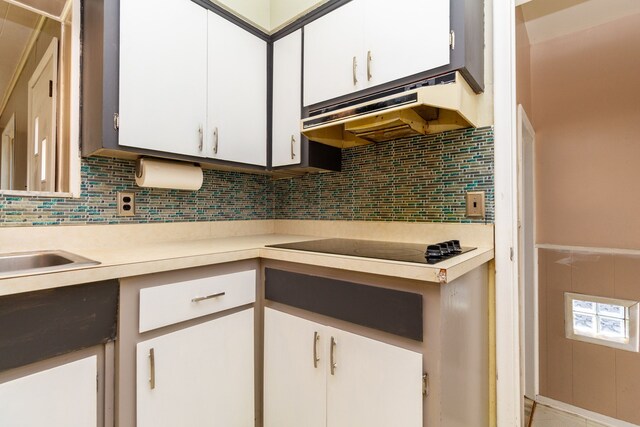 kitchen featuring black electric cooktop, white cabinets, and decorative backsplash