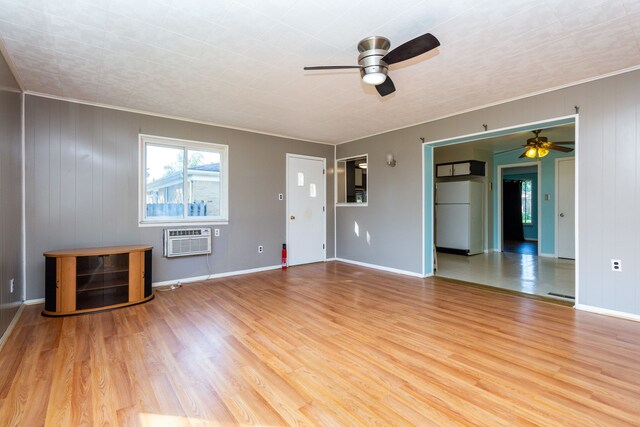 unfurnished living room featuring ornamental molding, ceiling fan, a wall mounted air conditioner, and light hardwood / wood-style flooring