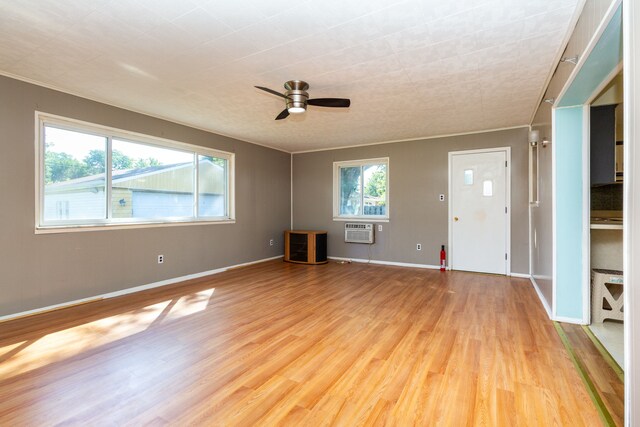 unfurnished living room with ceiling fan, light hardwood / wood-style flooring, and a wall unit AC