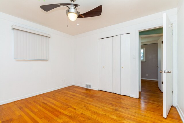 unfurnished bedroom featuring light wood-type flooring, ceiling fan, and a closet