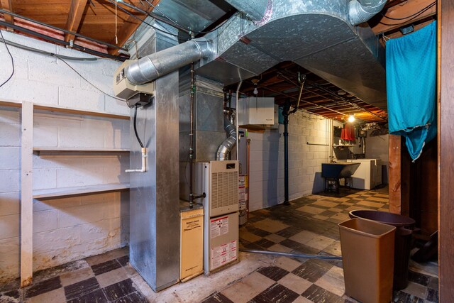 utilities featuring sink, water heater, and heating unit