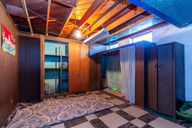 basement featuring wooden walls