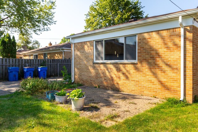 view of side of property featuring a patio and a yard