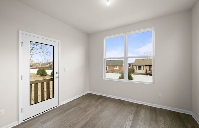 unfurnished room with baseboards and wood finished floors